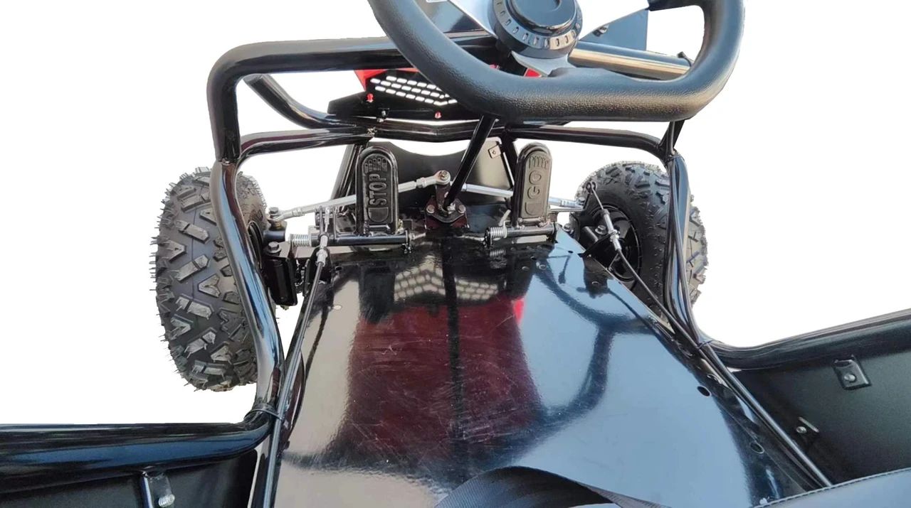 TrailMaster Cheetah 3 Kids Go-Kart, close-up view of the steering wheel, pedal system, and front tires.