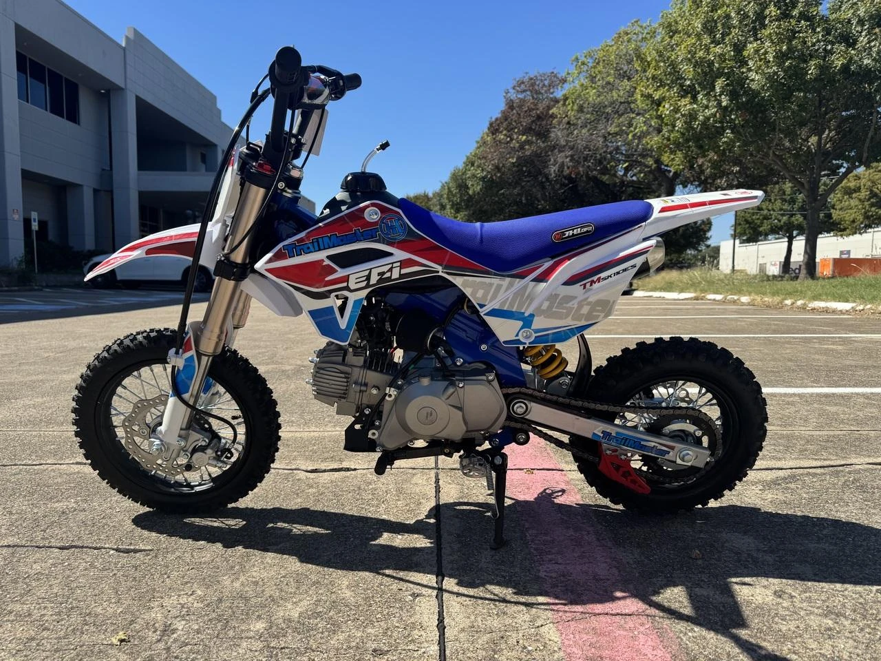 TrailMaster SK110S 110cc Semi-Automatic Kids Dirt Bike, yellow, black, white, and blue motocross motorcycle with knobby tires and suspension.