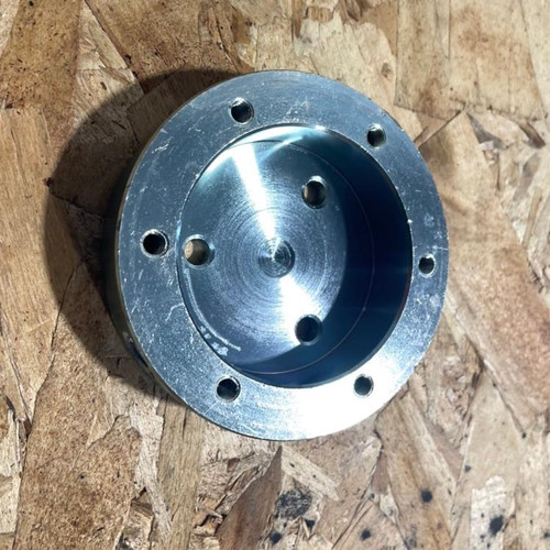 Trailmaster go karts Steering wheel adapter, metal circular component with multiple bolt holes for attaching a steering wheel to a go-kart.