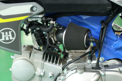 Trailmaster TM MK110 ES JHL Offroad Kids Dirt Bike, close-up of the engine and EFI system with a black air filter, showing mechanical details and wiring.