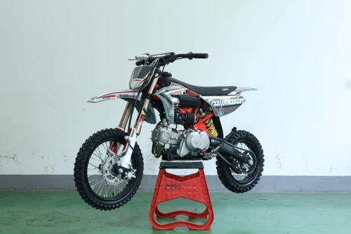 Trailmaster TM MK110 ES JHL Offroad Kids Dirt Bike, front view of the electric dirt bike with 29.5-inch seat height, EFI engine, and electric start, displayed on a red stand.
