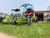 TM ASSEMBLED Mini XRX/R+ Go Kart with Reverse for Ages 4+ featuring a vibrant green frame, four large off-road tires, and a young child wearing a blue helmet sitting in the driver’s seat.