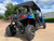 TM Challenger 4 200 EX 4 Seater 200cc SXS, side view of a rugged off-road utility vehicle with four large tires, blue body, black roof, and seating for four passengers in an outdoor parking lot.