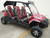 TM Challenger 4 200 EX 4 Seater 200cc SXS, red and black off-road utility vehicle with four seats, roll cage, and rugged tires.