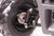 TM 3125R ATV, close-up of the front wheel and suspension system showing rugged tire and durable mechanical parts.