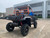 TM 4x4 SportsCross 1000 Side by Side, rugged off-road utility vehicle with large tires, orange roll cage, and black body, parked in an outdoor lot.