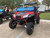 TM 4x4 SportsCross 1000 Side by Side, rugged off-road vehicle with black and red body, large off-road tires, front grille, and protective windshield.