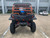 TM 4x4 SportsCross 1000 Side by Side, a rugged off-road vehicle with orange roll cage, large tires, and dual seats, parked in an outdoor lot.