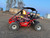 TM 200 XRS EFI Adult GoKart, red off-road go-kart with a protective roll cage, and two children wearing helmets inside, on a dirt track.