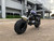 TM Hurricane 200X Upgraded Mini Bike, off-road mini bike with black tires, blue and black body, and rugged design in parking lot.
