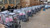 TM Milano 50N Scooter Moped, pink scooters stored in protective plastic covers within metal display frames, arranged in a large indoor warehouse setting.