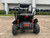 TM Blazer i200R Mid Size Battery Powered Go Kart, front view of black off-road electric go-kart with large tires, suspension, and safety bars in an outdoor parking lot.