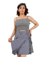 Woman lifting grey hybrid kilt apron to show inner gingham panel