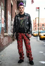 Man in punk-style plaid pants in red and black with straps and zips, street setting