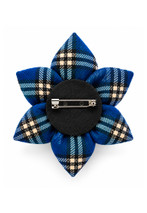 Back of a tartan petal brooch in blue tartan, showing the black felt backing and pin