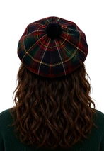 Tartan tam in dark green and red plaid with navy pom-pom, back view on a woman
