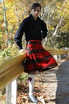 Side view of boy in Maxwell tartan kilt with kilt hose, leaning on railing