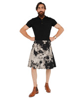 Man with hands on hips in black and grey bleached denim kilt, front view