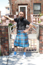 Man in Orkney tartan kilt leaning an arm on a brick gate post
