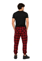 Man in navy and green tartan trousers with a green T-shirt, back view