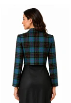Cropped bolero jacket in blue, green and black tartan over a black dress, back view
