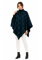 Woman wearing a tartan cape in dark navy and green plaid with white trousers, front view