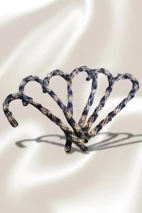 Tartan candy cane ornaments wrapped in navy and cream plaid arranged on satin