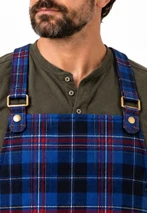 Close-up of a blue tartan grilling apron bib with adjustable straps and metal buckles