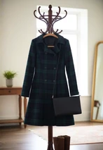Dark green and navy tartan Kate coat on a coat stand with a black shoulder bag