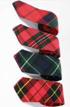 Four narrow tartan ties in red and green tartans arranged in a row