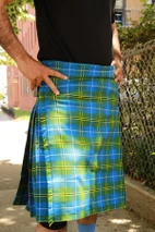 Close-up of blue, green and yellow tartan kilt apron and pleats worn outdoors