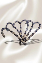 Tartan candy cane ornaments wrapped in navy and cream plaid arranged on satin