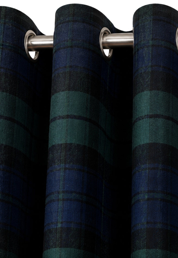 Close-up of navy and green tartan curtains hung on metal eyelets