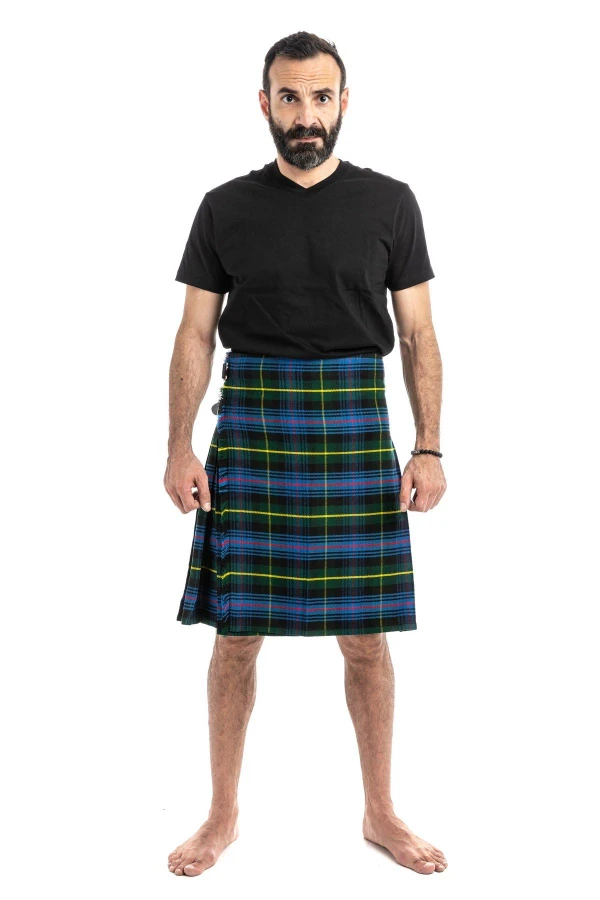 Man in navy and green tartan trousers with a green T-shirt, back view