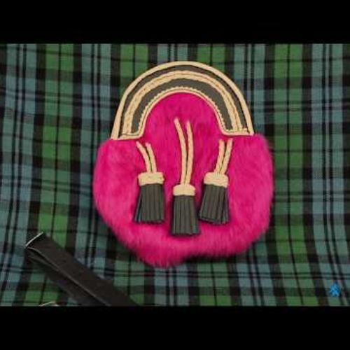Pink fur full dress sporran with three tassels on green tartan fabric