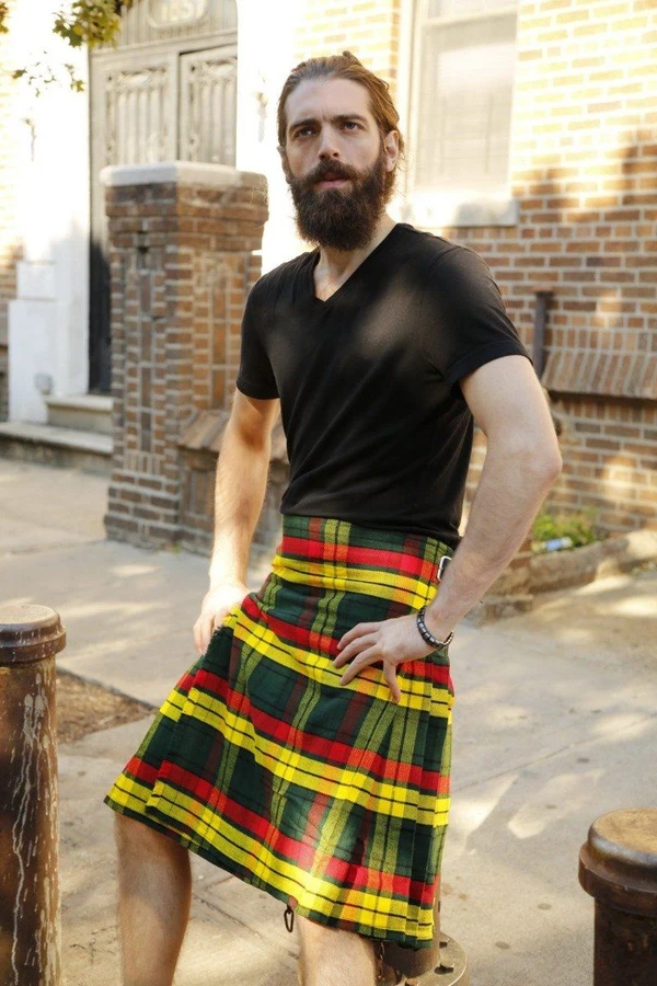 Man in MacMillan yellow, red and green tartan kilt standing on a street