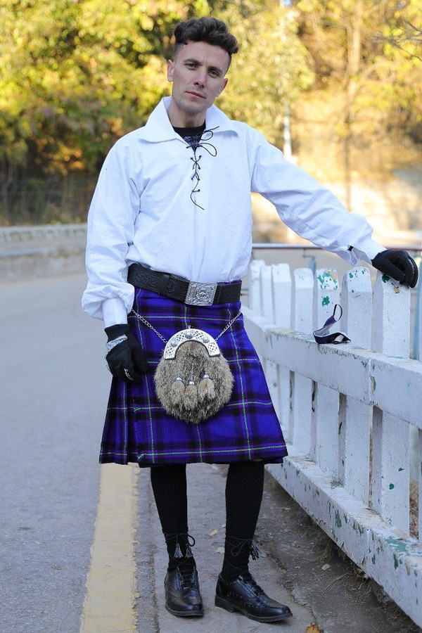 Man in blue and purple tartan kilt with fur sporran and white ghillie shirt