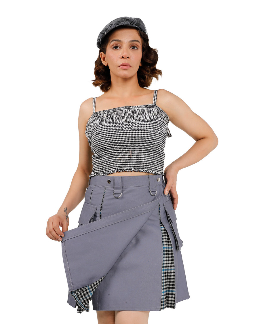 Woman lifting grey hybrid kilt apron to show inner gingham panel