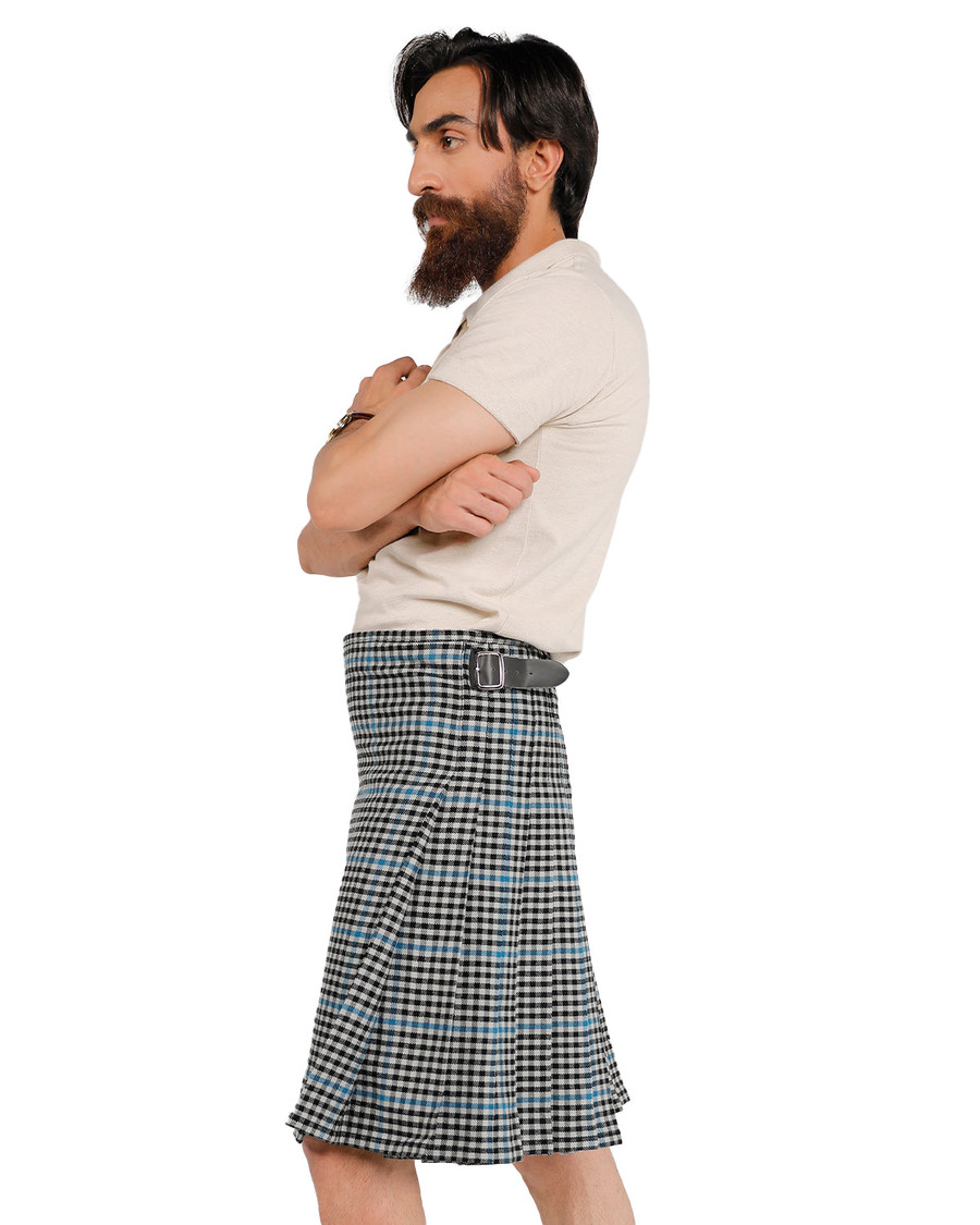 Man wearing a bespoke kilt in black, white and light blue check tartan, side view