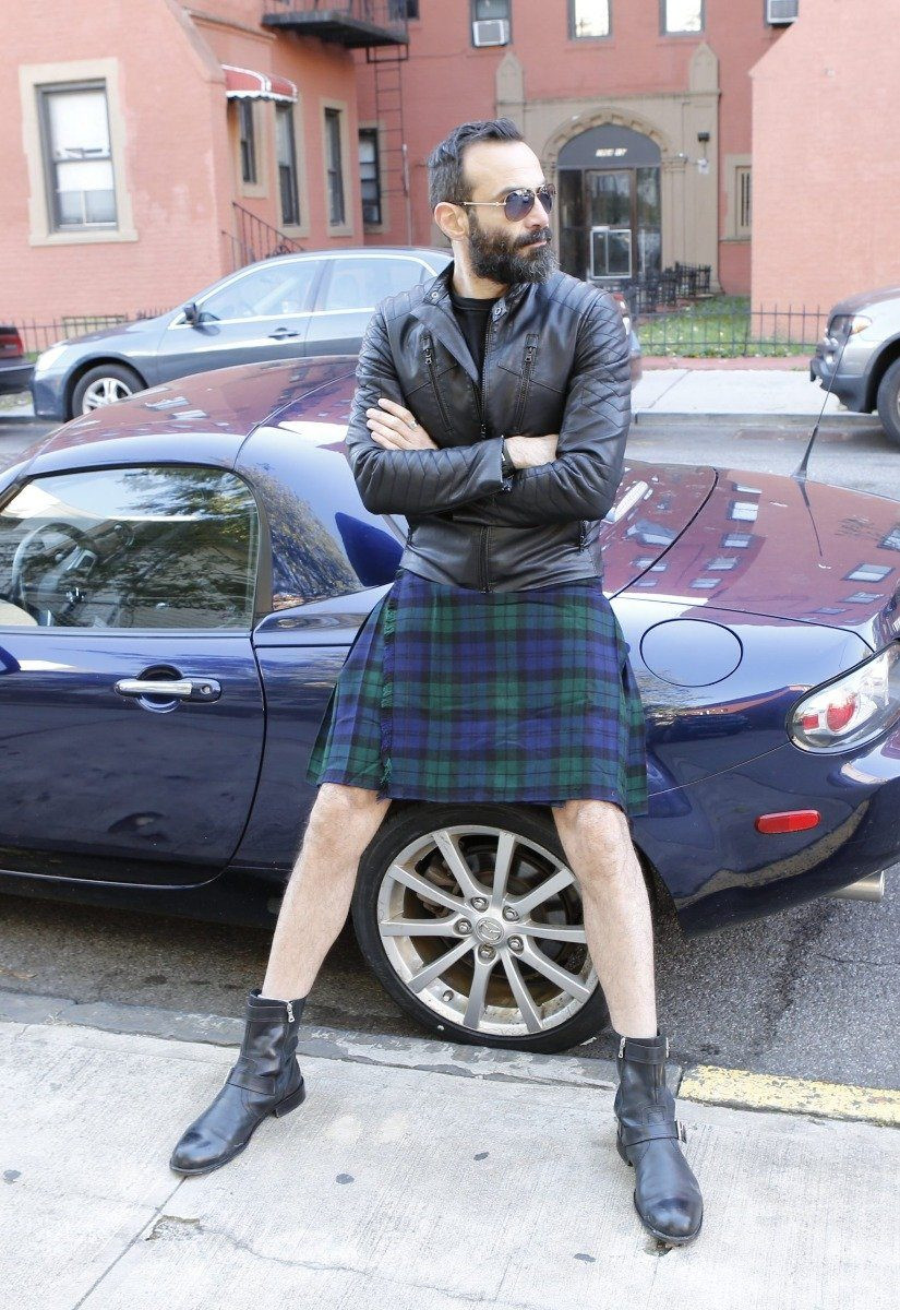 Man in MacKay tartan kilt and leather jacket sitting on a car bonnet outdoors