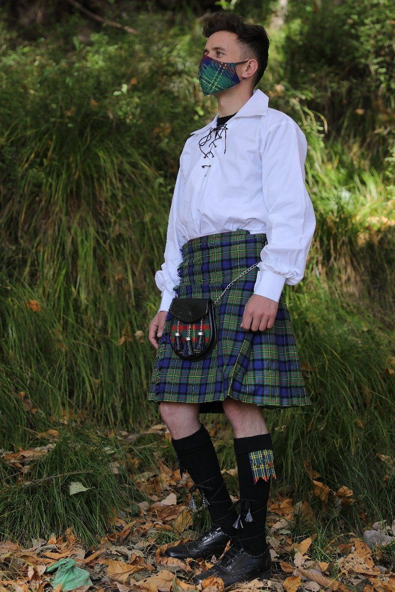Man in MacLaren tartan kilt with sporran and ghillie shirt outdoors, side view