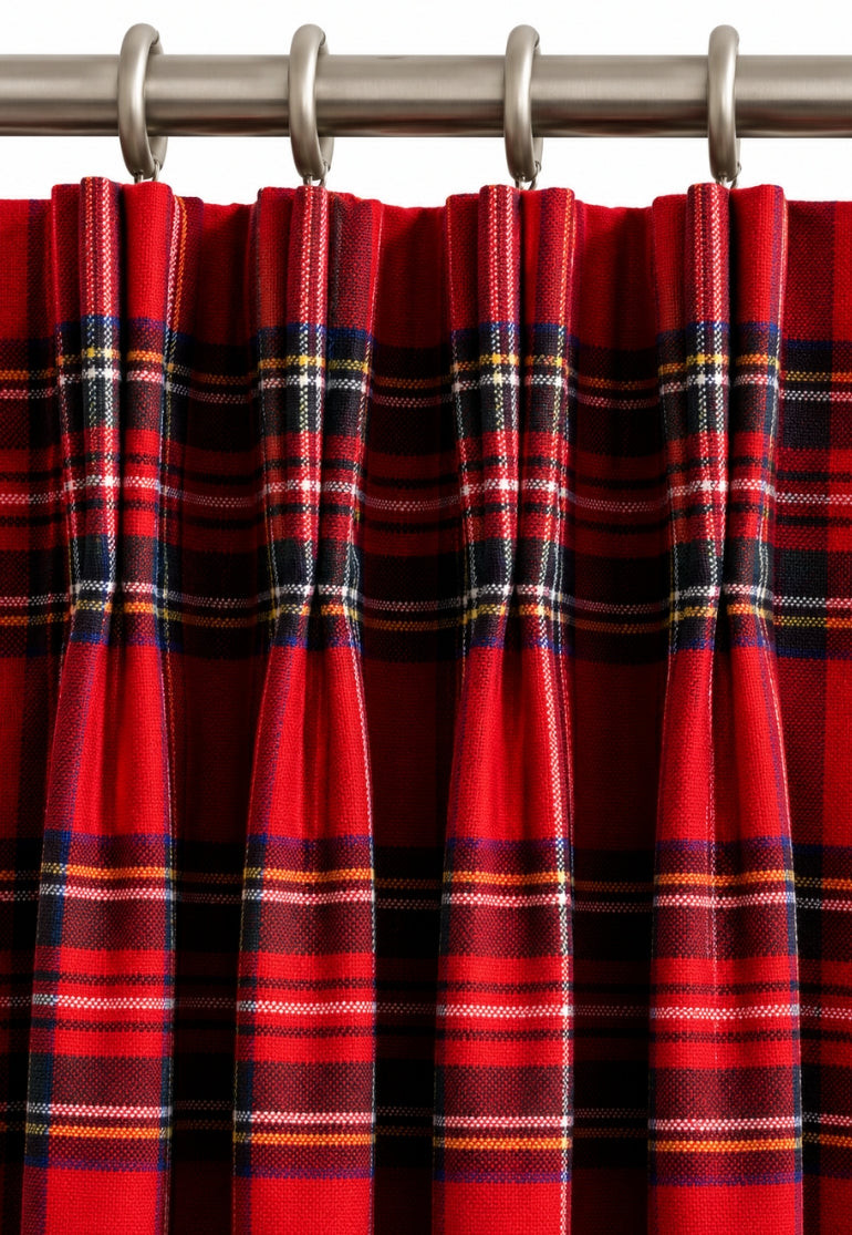 Close-up of red tartan pinch pleat curtain heading on metal rings