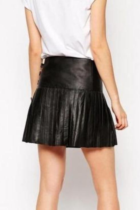 Back view of black pleated leather mini skirt worn with white T-shirt