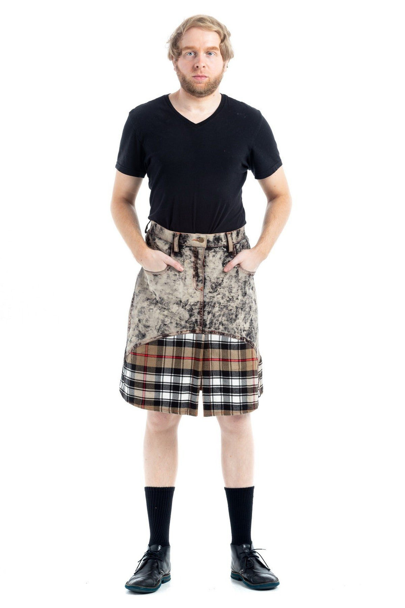 Full-length view of man in denim tartan kilt with hands in front pockets, black socks