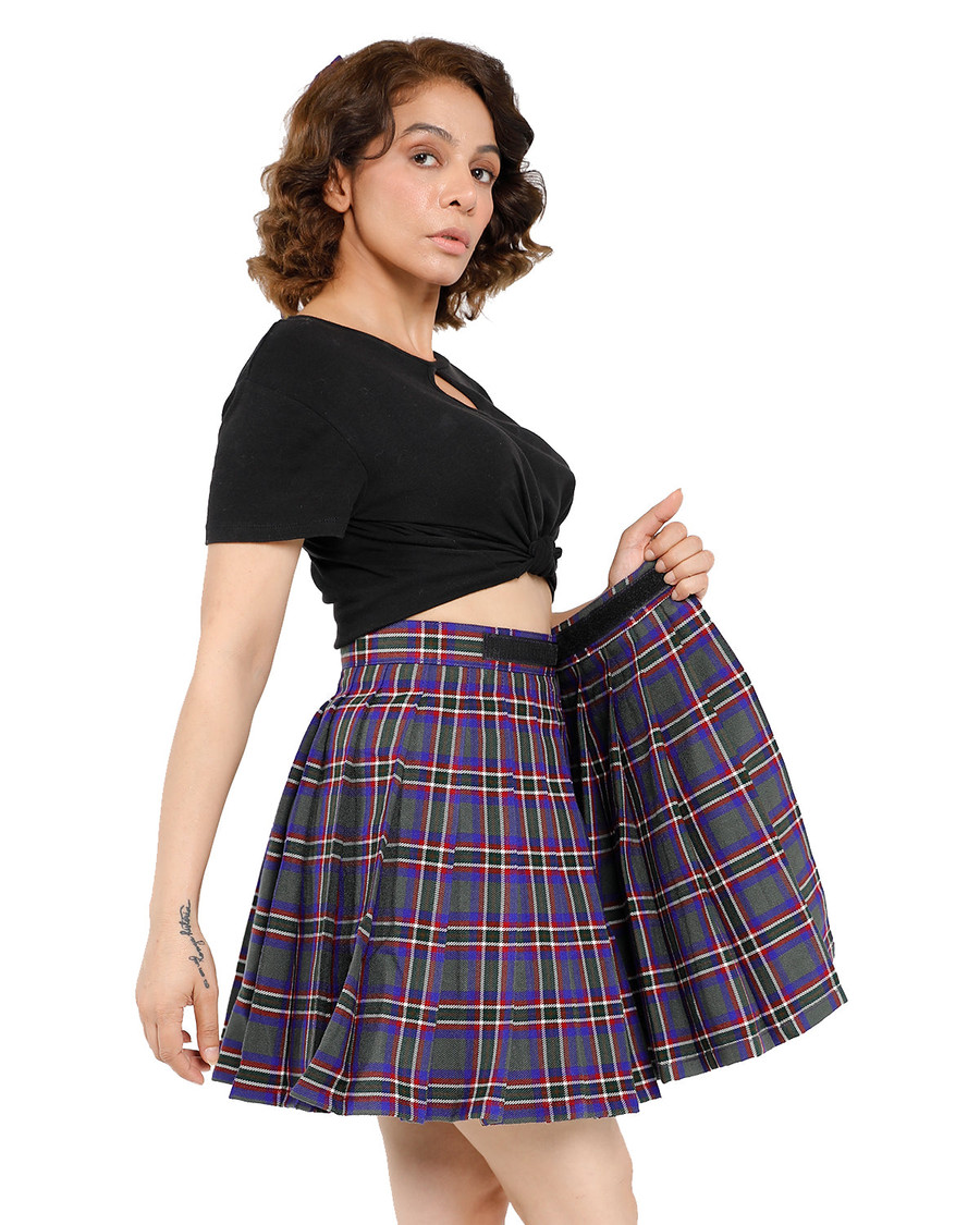 Woman lifting hem of purple tartan wrap-around pleated skirt to show pleats
