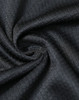 A close-up of black jacquard knit fabric, displaying a textured swirl pattern with a smooth finish.
