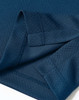A close-up of a navy blue sustainable jacquard knit polo, highlighting the fabric texture and stitching details.