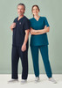 A unisex scrub top in navy and teal, worn by a male and female model, with a stethoscope and casual grey shoes.