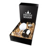 A stainless steel wine glass with a sleek design, presented in a black gift box with festive decorations and straw filling.