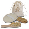 A travel set featuring a wooden hairbrush, exfoliating pad, small brush, and a beige drawstring bag with a logo.